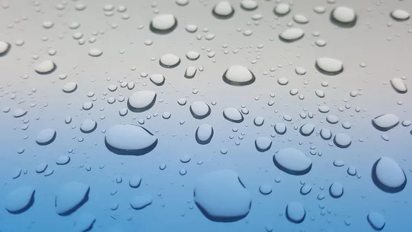 Módulos fotovoltaicos em telhado residencial com gotas de chuva escorrendo sobre o vidro