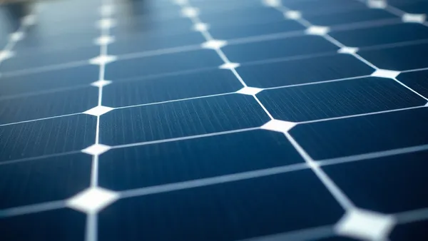 Folha de datasheet técnico de módulo fotovoltaico com parâmetros elétricos em destaque sobre bancada de engenharia