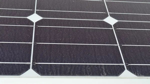 Close de células fotovoltaicas em módulo solar mostrando barramentos metálicos