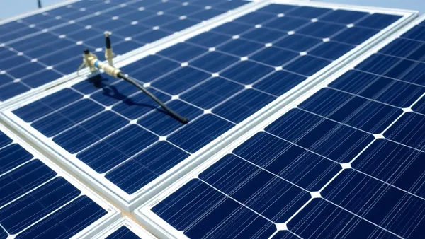 Técnico em frente a poste de distribuição elétrica consultando documentos de homologação de sistema solar fotovoltaico