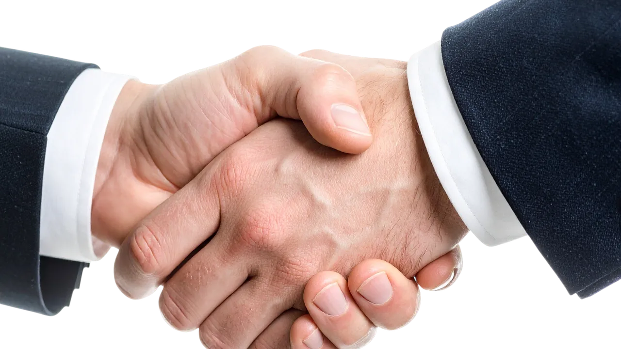 Aperto de mãos em fechamento de contrato comercial, simbolizando acordo entre cliente e integradora solar