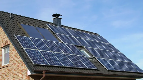Painéis fotovoltaicos instalados no telhado inclinado de uma casa residencial
