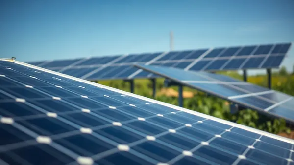 Planilha de inventário de cargas elétricas sendo preenchida ao lado de painel solar off-grid em propriedade rural